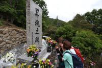 Bereaved family members and others pray for the victims on Tuesday in front of a monument at the site of the Japan Airlines jumbo jet crash in the village of Ueno, Gunma Prefecture, 40 years ago.