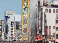 Firefighters work to extinguish fire at a building near the Dotonbori River in the city of Osaka on Monday.