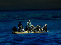 A scene from a play about the 1944 sinking of the Tsushima Maru, where the protagonist and others are drifting at sea on a raft, in Naha, Okinawa Prefecture, on Aug. 16