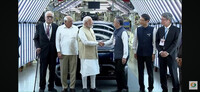 Indian Prime Minister Narendra Modi (center left) and Suzuki Motor President Toshihiro Suzuki shake hands at a plant in Gujarat, western India, on Tuesday. (Courtesy of the automaker)